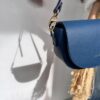 Indigo blue Alma bag hanging with its shadow projected on the wall