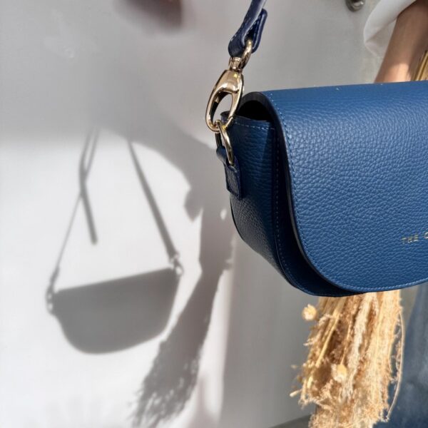 Bolso Alma azul índigo colgado con su sombra proyectada sobre la pared
