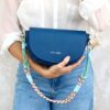 Model holds The Code Alma blue indigo front-shaped bagl