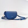 Indigo blue Alma bag on a light surface