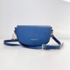 Indigo blue Alma bag resting on a flat surface