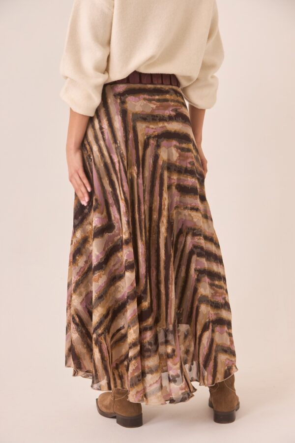 Back shot of Nekane's fluid asymmetric skirt featuring animal-inspired print and earthy tones