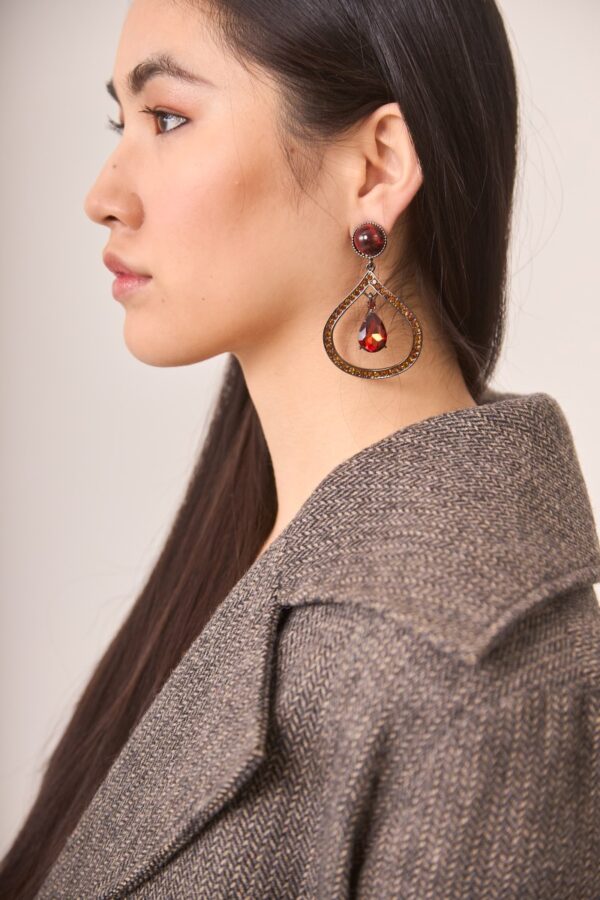 Side view of boho drop earrings in dark metal with teardrop shape